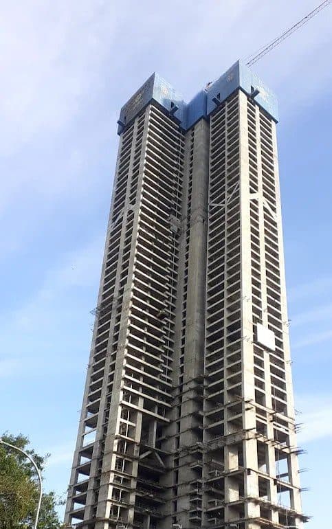 Reinforced concrete frame of a high-rise tower under construction against a clear sky